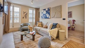 A modern living room with a sofa, coffee table, and decorative items. - Sublim Apartement in the Center of Paris/le Marais (Paris)