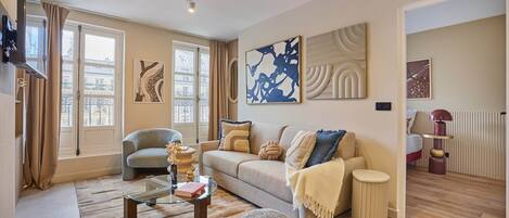 A modern living room with a sofa, coffee table, and decorative items.