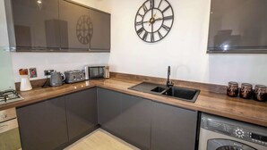 A modern kitchen with a built-in dishwasher, a microwave, a toaster, and a sink.