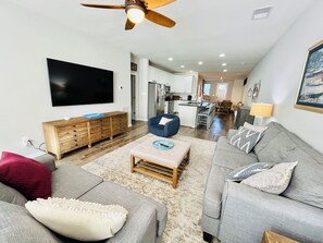 Relax in this stylish living space with a flat-screen TV, sofa, and ottoman.
