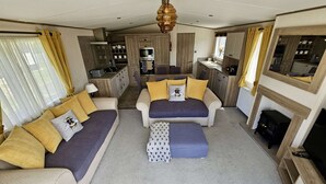 A compact living space with a sofa set, a small ottoman, a television, and a fireplace. - Daisy, A Hot Tub Home, Also Dog Friendly (Hoburne Holiday Park)
