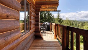 A wooden log cabin with a deck, a covered grill, and a view of the surrounding forest. - Spa and Great Comfort | Le Bo Bois Rond (Saint-Michel-des-Saints)