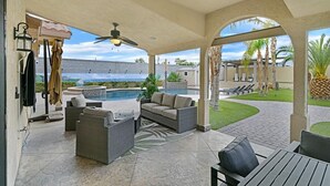 A covered outdoor area with a pool, patio furniture, and a view of the ocean. - Luxury 6BR Vegas Villa w Pool &Spa, Near The Strip (Las Vegas)