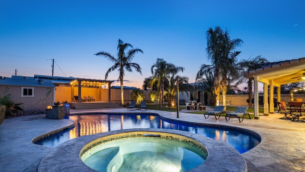 A swimming pool with a hot tub, lounge chairs, palm trees, and a covered patio area. - Luxury 6BR Vegas Villa w Pool &Spa, Near The Strip (Las Vegas)
