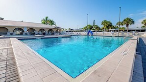 A rectangular swimming pool with a tiled deck surrounding it.