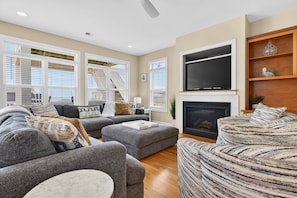 A living room with a fireplace, a flat-screen TV, and a sofa set.