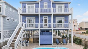 Une maison à deux étages avec une piscine, une terrasse couverte et un escalier menant à l’étage supérieur.