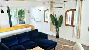 A modern living room with a blue sectional sofa, a wooden coffee table, and a white armchair. - Sunset View (Saint Martin)