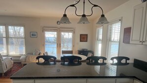 A kitchen with a large island, white cabinetry, and a view of the outdoors through the windows. - Waterfront retreat with private dock, hot tub, sauna and spectacular gulf views (Georgetown)
