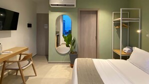 A hotel room with a bed, a desk with a chair, a TV, a wardrobe, and a mirror. - w Impeccable Loft w Charming Terrace in CTG (Cartagena)