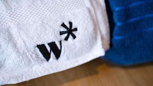 A white towel with a black embroidered symbol. - w Exceptional Loft w Great Terrace in CTG (Cartagena)