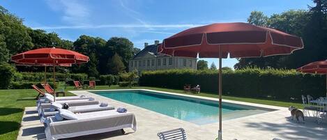 Een seizoensgebonden buitenzwembad en parasols bij het zwembad