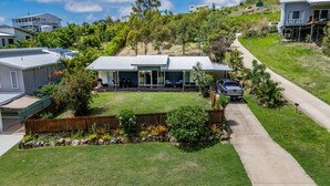 A residential property with a fenced backyard, a driveway, and a garage. - Bayview • Pet-Friendly Beach House for 6 • Fenced Yard • Walk to Beach (Agnes Water)