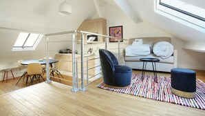 A loft-style bedroom with a high ceiling, skylight, a bed, a desk, and a chair. - Sublime and new Triplex Le Marais/beaubourg (Paris)