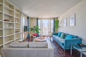 Un salon moderne avec un canapé, une table basse et une bibliothèque.