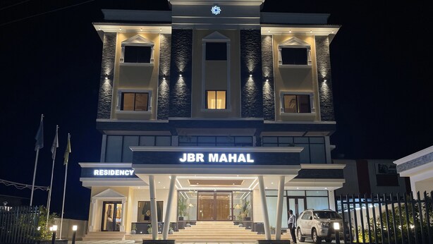 Een meerlaags gebouw met een bord waarop 'JBR MAHAL RESIDENCY' staat.