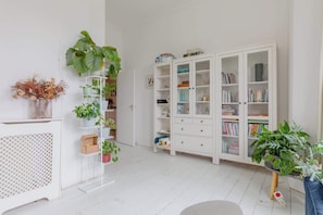 A room with a white bookshelf, a white console table, and a white cabinet. - Homely 2BD Flat with Private Garden, North London (Greater London)