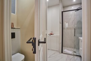 A modern bathroom with a glass-enclosed shower, a white toilet, and a marble floor. - Sublim new Flat Center of Paris Opera Madeleine (Paris)