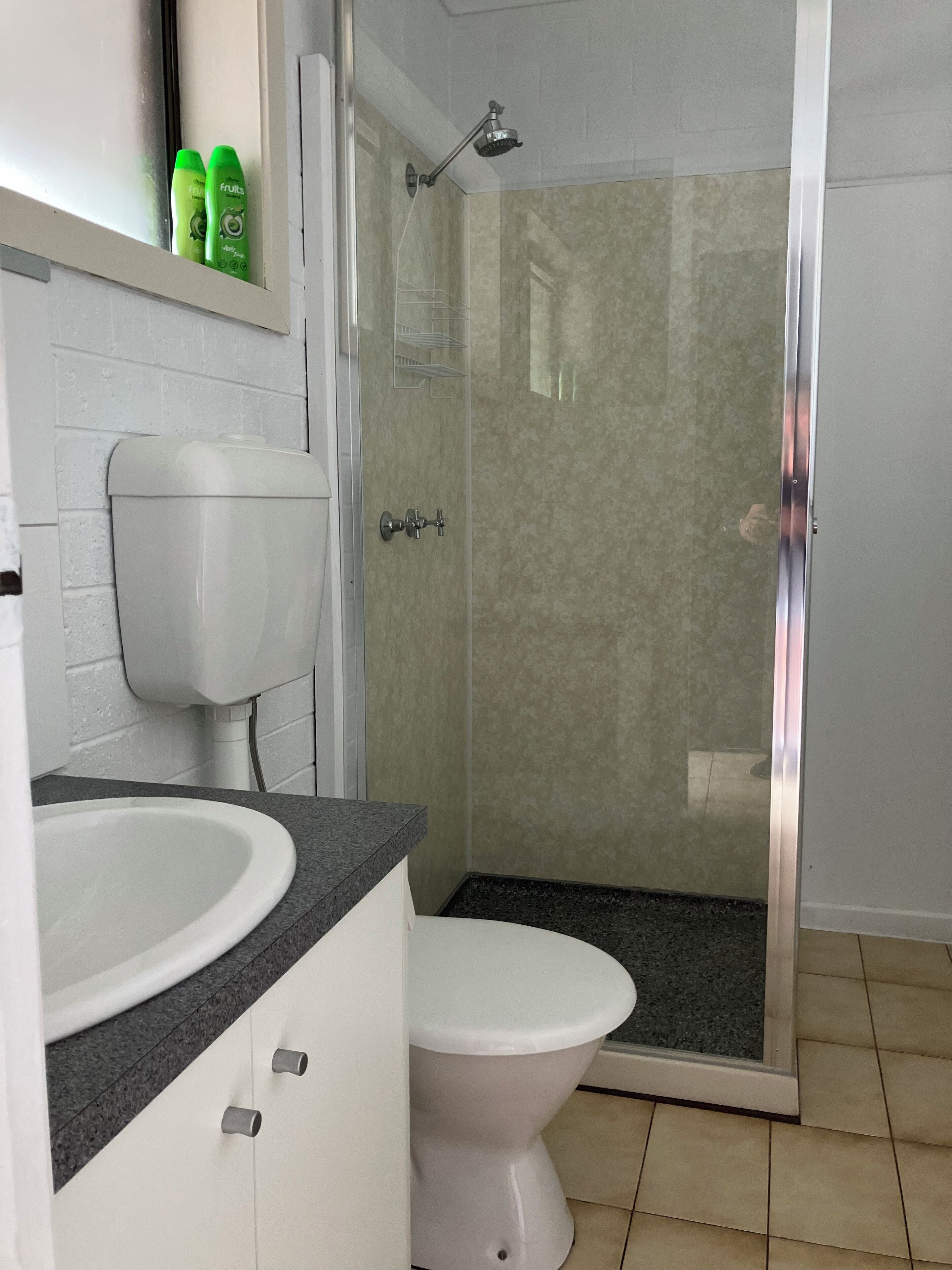 Un baño con ducha, inodoro y lavamanos.