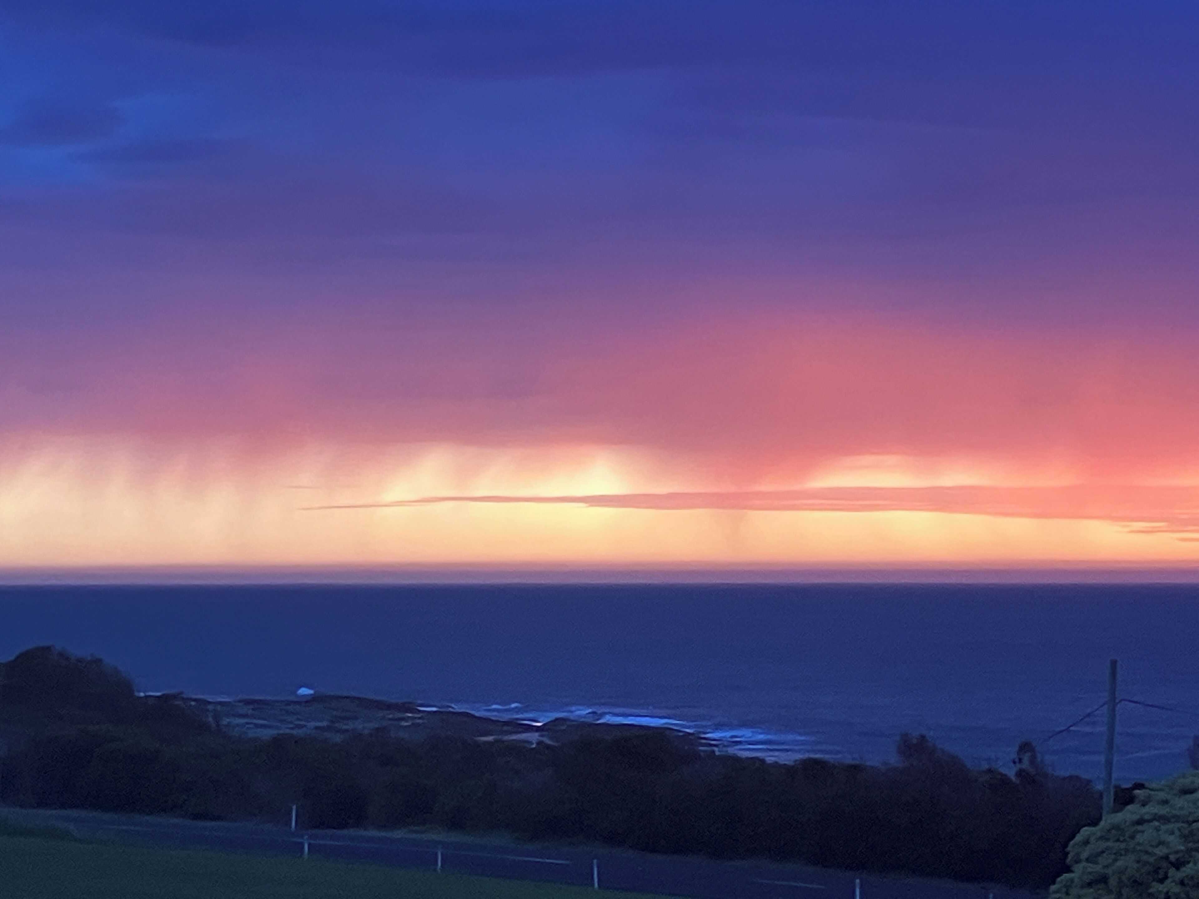 Tramonto sulla costa, cielo sereno e vista sull'oceano.