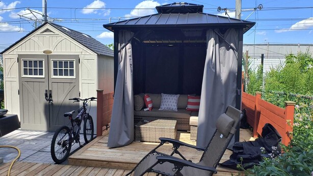 A covered outdoor seating area with a bench and a bicycle. - Large, luxurious apartment in Ville Saint-Laurent  (Montréal)