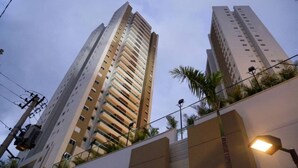 Un edificio moderno y alto, con múltiples pisos y balcones.
