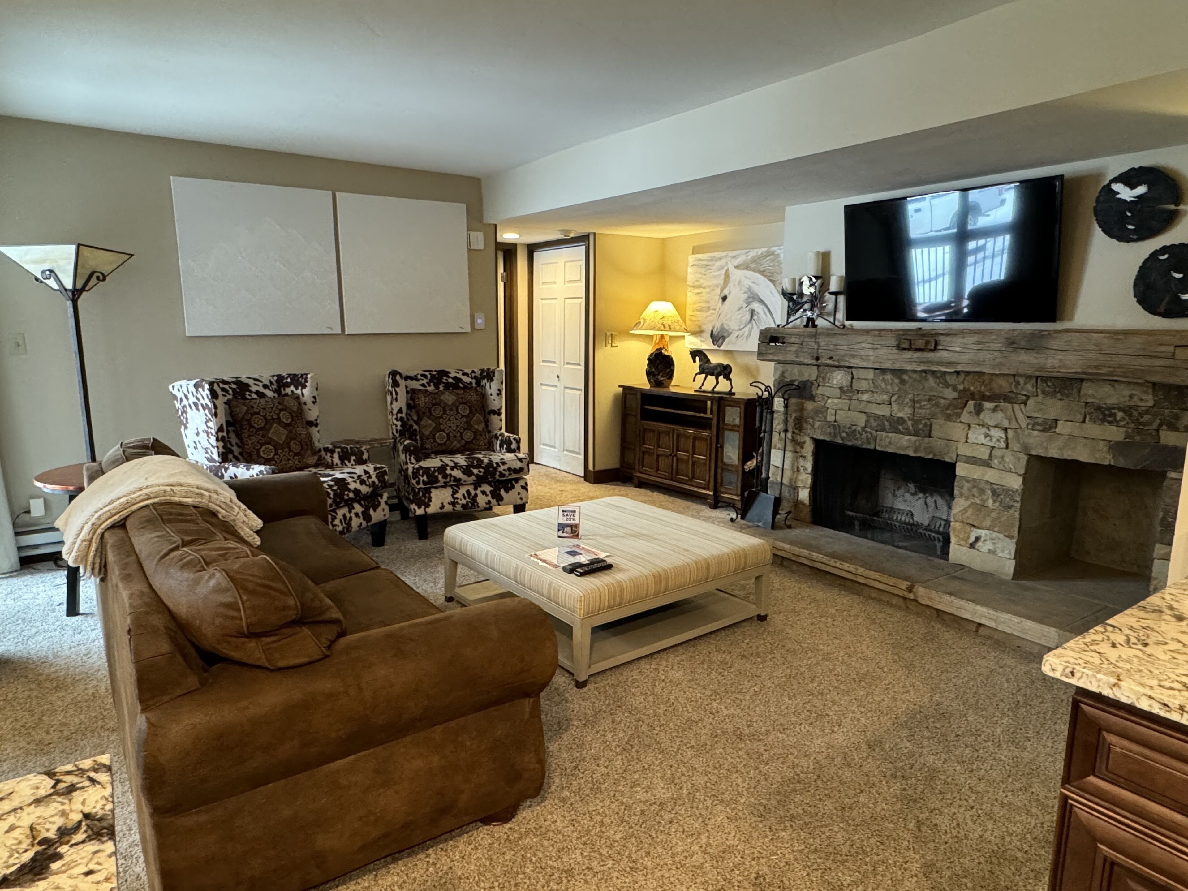 Una sala de estar con chimenea, televisor y sofá.