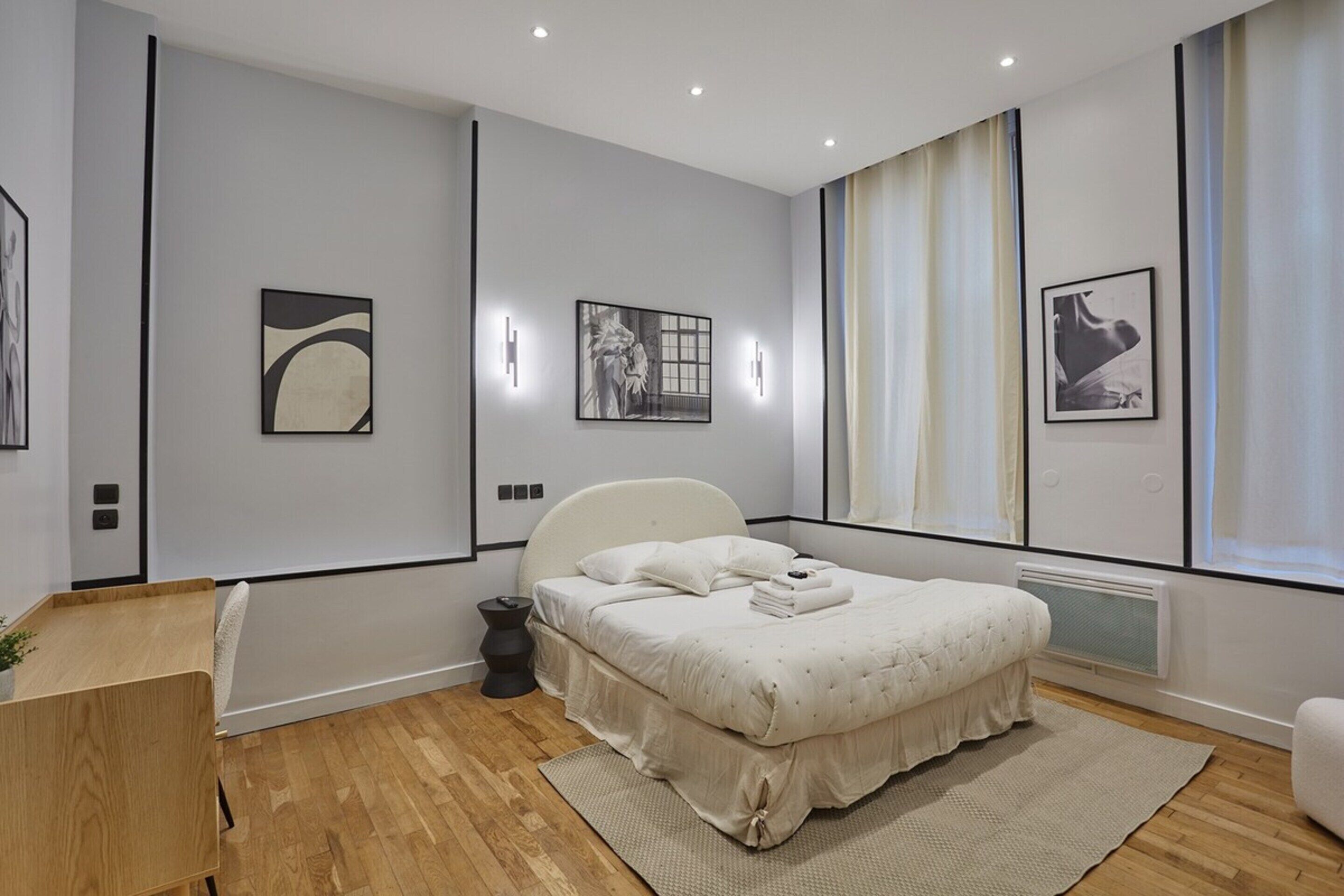 A modern bedroom with a large bed, a bedside table, and a chair.