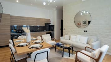 A modern living space with a dining area, kitchen, and seating area.