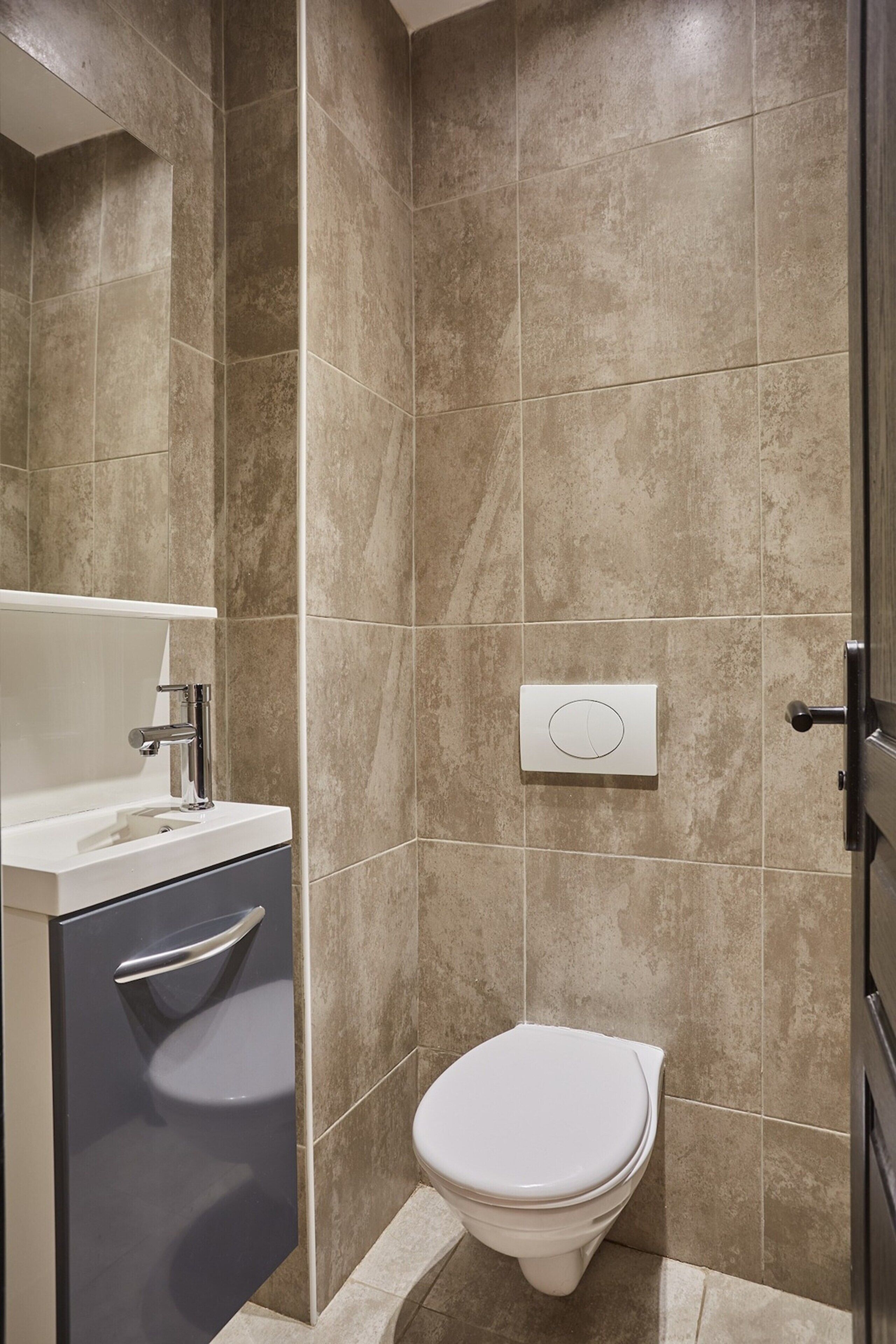 Ein Badezimmer mit Toilette, Waschbecken und Duschbereich.