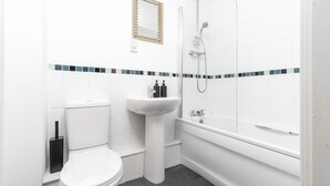 A bathroom with a toilet, sink, and shower.