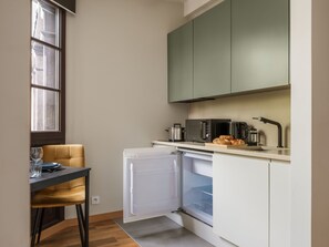 A compact kitchen with a microwave, toaster, and a small refrigerator. - Studio standard for two. (Kraków - Kazimierz & Podgórze)