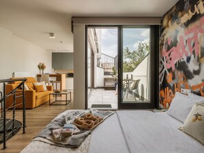 Une chambre moderne comprenant un lit, un canapé, un coin repas et un balcon avec vue.