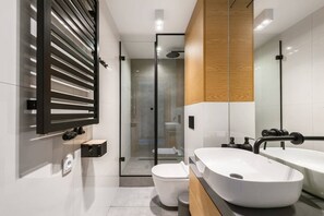 A modern bathroom with a glass shower enclosure, two sinks, and a toilet. - Studio with a mezzanine (Kraków - Kazimierz & Podgórze)