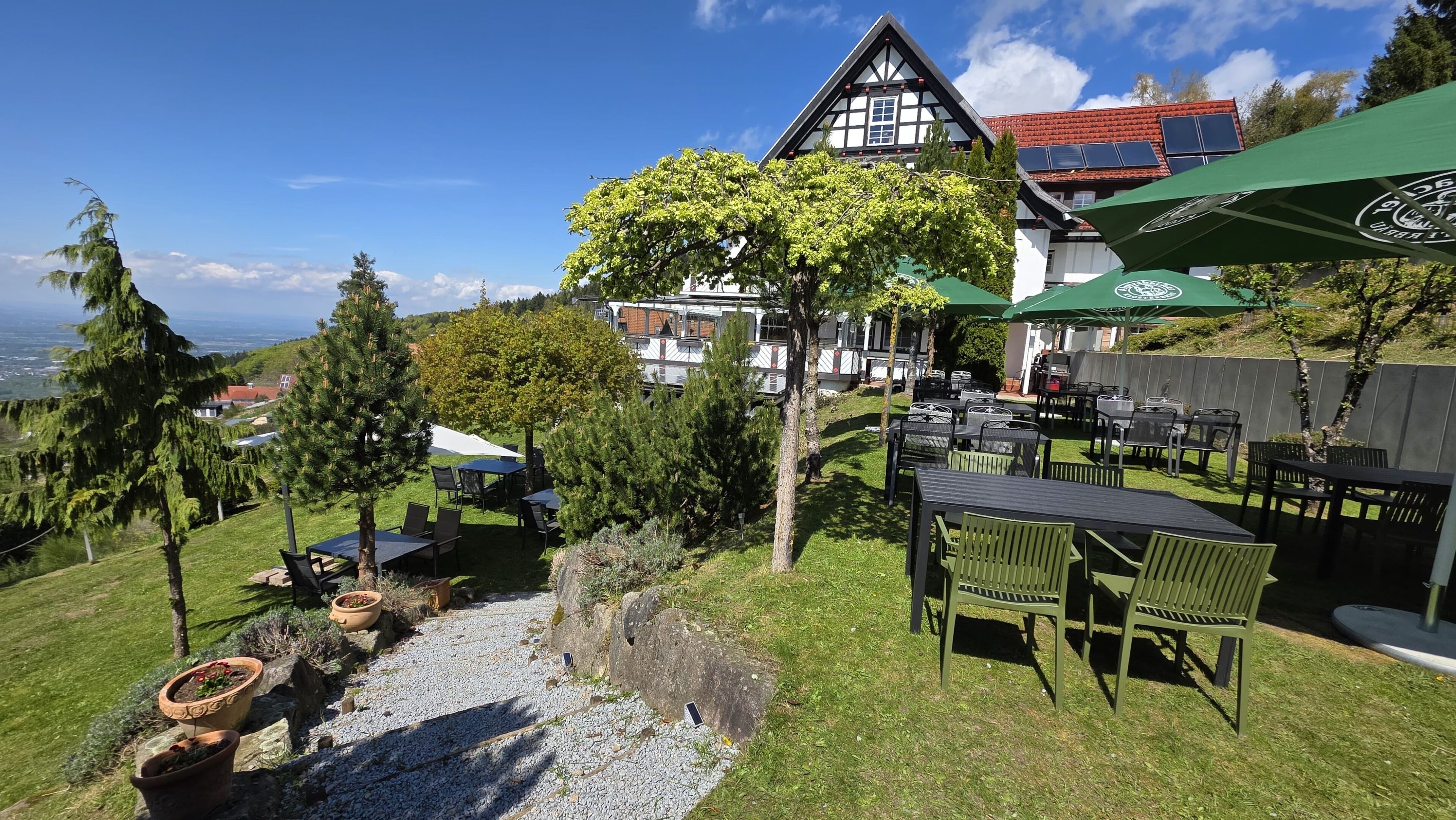 A chalet-style building with outdoor seating and a view of the landscape.