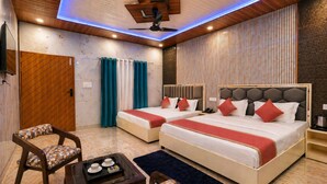 A hotel room with two beds, a wooden ceiling, a TV, and a small table with cups. - Aqua Tree Resort (Mohan Chatti)
