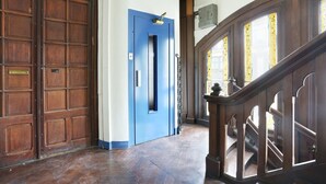 A hallway with a blue door, wooden double doors, and a wooden staircase. - Superb Apartement 2 Bedrooms Center of Paris (Paris)