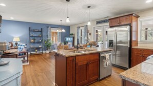 A spacious kitchen with wooden cabinets, a stainless steel refrigerator, and a granite countertop. - Beautiful 3 bedroom ranch home in Smyrna near the Braves stadium  (Smyrna)