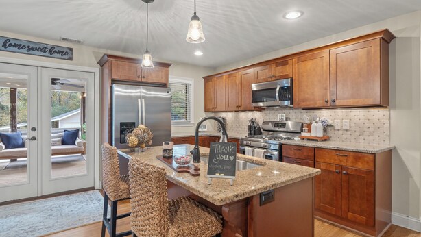 A modern kitchen with wooden cabinets, stainless steel appliances, and a granite countertop. - Beautiful 3 bedroom ranch home in Smyrna near the Braves stadium  (Smyrna)