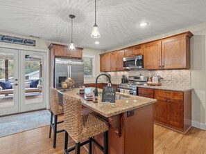 A modern kitchen with wooden cabinets, stainless steel appliances, and a granite countertop.