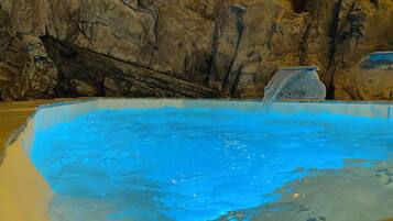 Relax by the pool surrounded by natural scenery and a soothing waterfall.