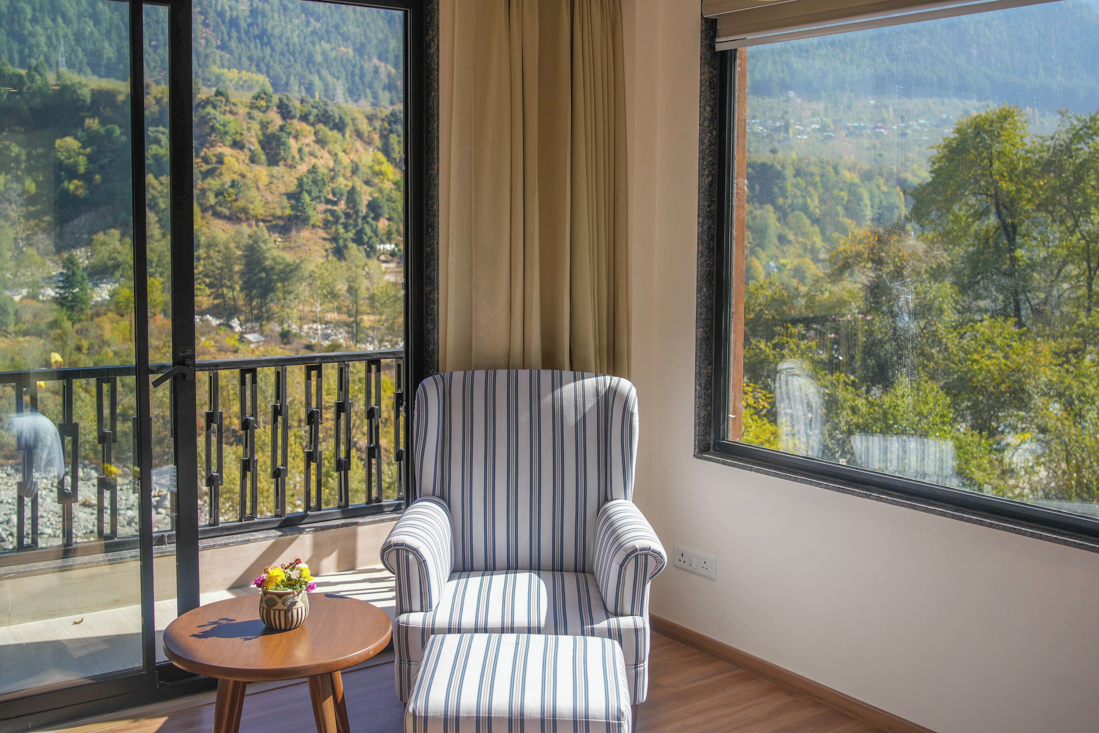 A room with a large window offering a scenic view of a forested area.