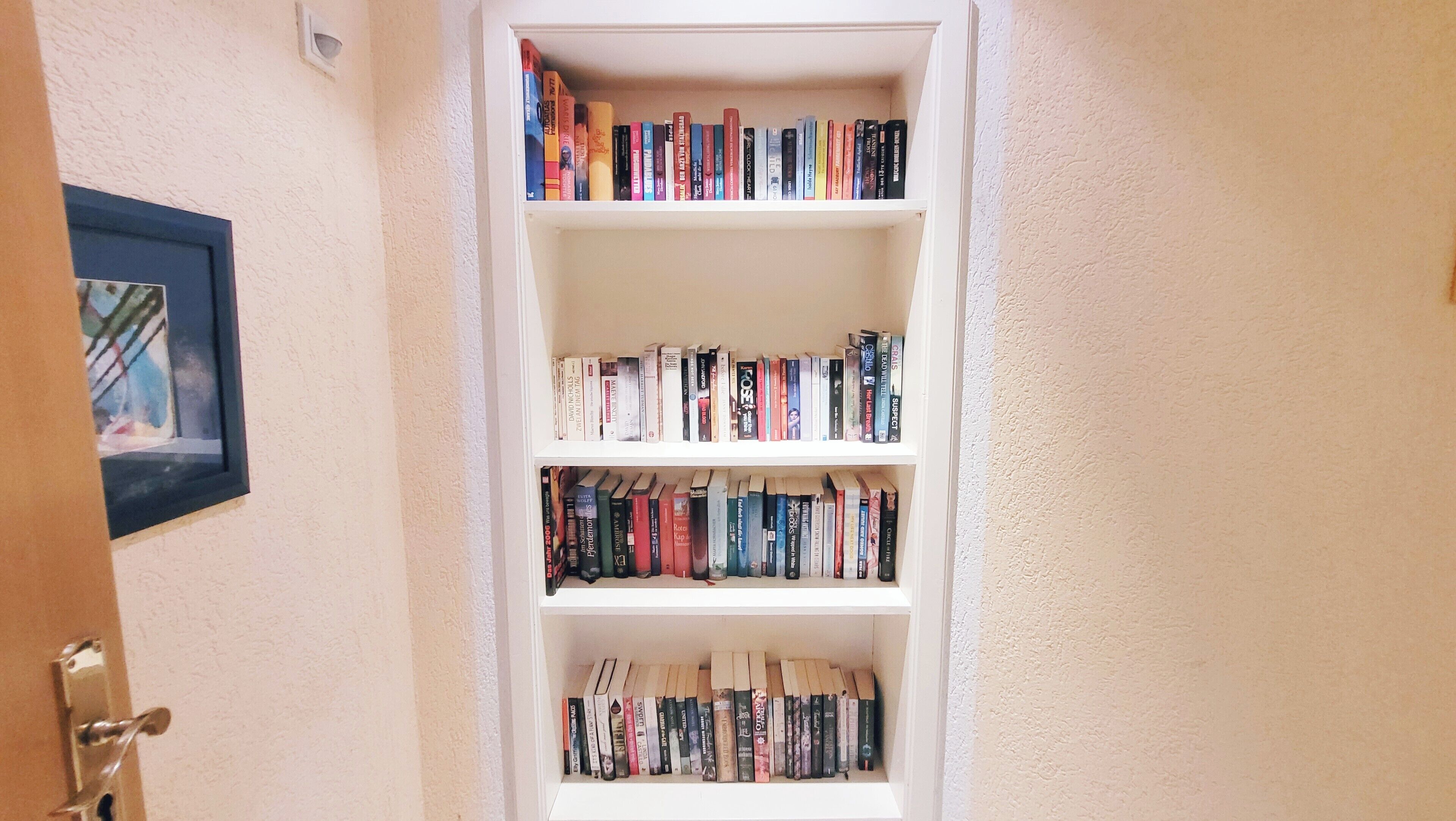 Une bibliothèque avec plusieurs étagères remplies de livres.