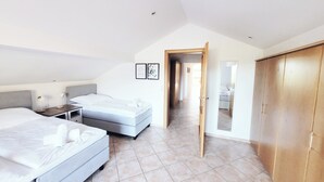 A modern bedroom with a large bed, a smaller bed, a desk, and a wardrobe. - Cosy holiday flat in Bodenmais I Sauna I Balcony I View Silberberg (Bodenmais)