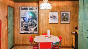 A dining area with a round table, red chairs, and a chandelier.