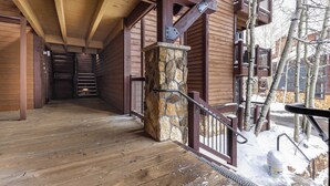 A wooden staircase with stone accents leading to a balcony.