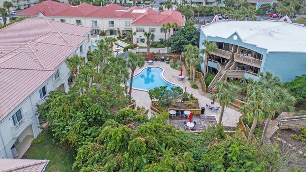 A resort with a swimming pool surrounded by palm trees and a view of the ocean. - Ocean Hibiscus Retreat – For 8 (St. Augustine)