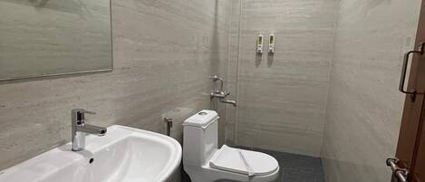 A modern bathroom with a sink, toilet, and shower.