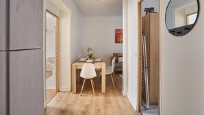 A modern kitchen with wooden cabinets, a dining table with chairs, and a mirror on the wall. - Apartment Paris Exposition Park Center (Paris)