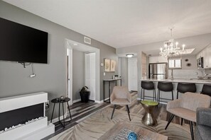 Cozy living space with a flat-screen TV, fireplace, and dining area.